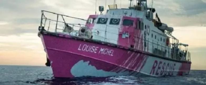 Dopo l'allarme della nave di Bansky, arriva una motovedetta della Guardia costiera. Ma i migranti non possono sbarcare